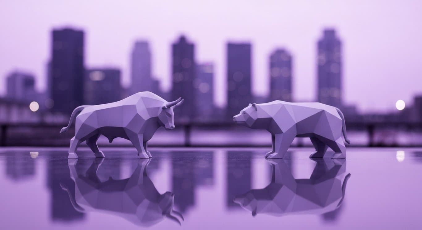 Abstract bull and bear sculptures on a reflective surface with a blurred city skyline behind them